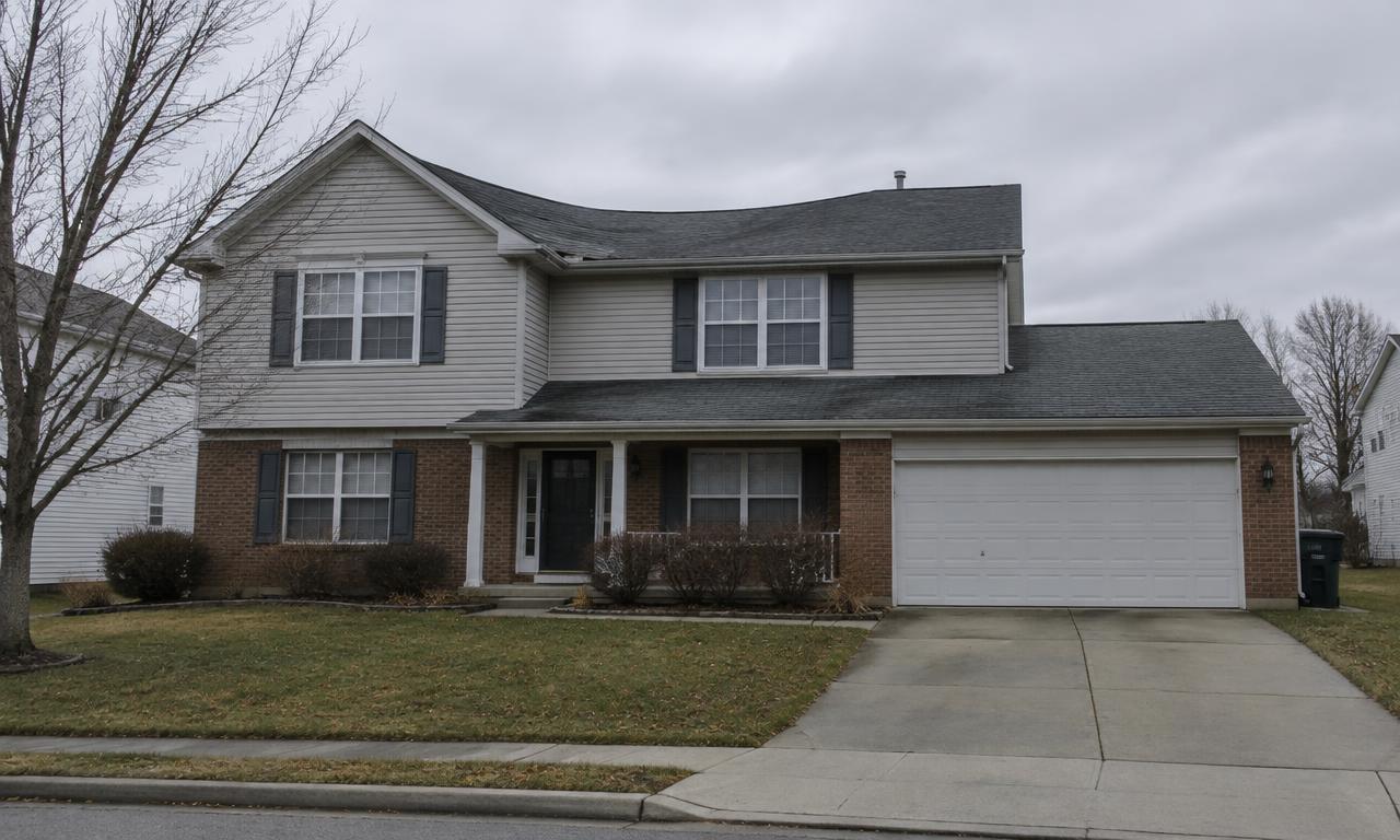 A two-story home seen from the street with a clear dip in the roofline between the ridge and the lower roof